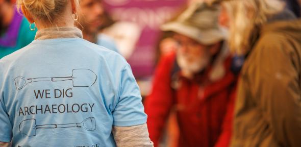 © English Heritage Trust Person wearing 'We Dig Archaeology' t-shirt